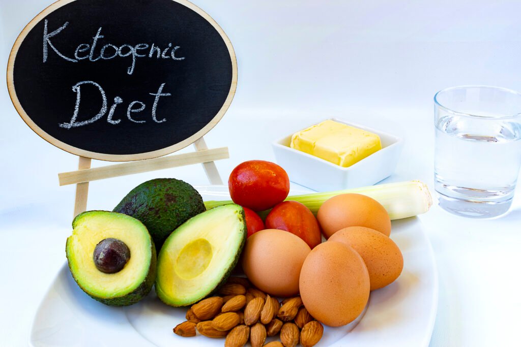 A balanced plate illustrating a ketogenic diet with avocados, nuts, eggs, and leafy greens, symbolizing healthy fat, moderate protein, and low carbohydrate intake.