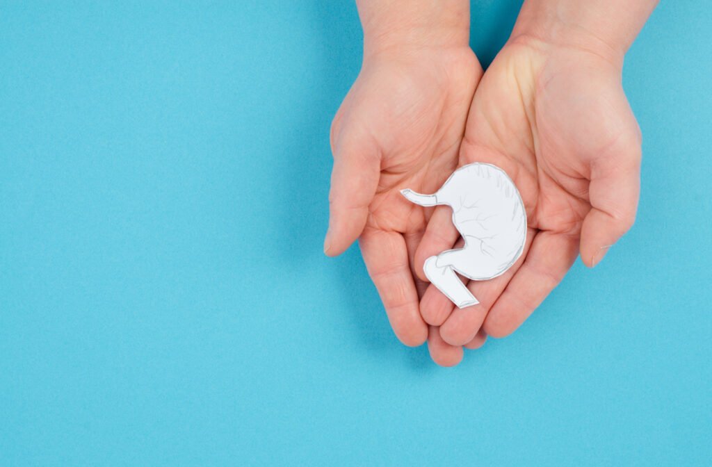 Holding a stomach in the hand, inflammation digestive system, gastrointestinal health issues