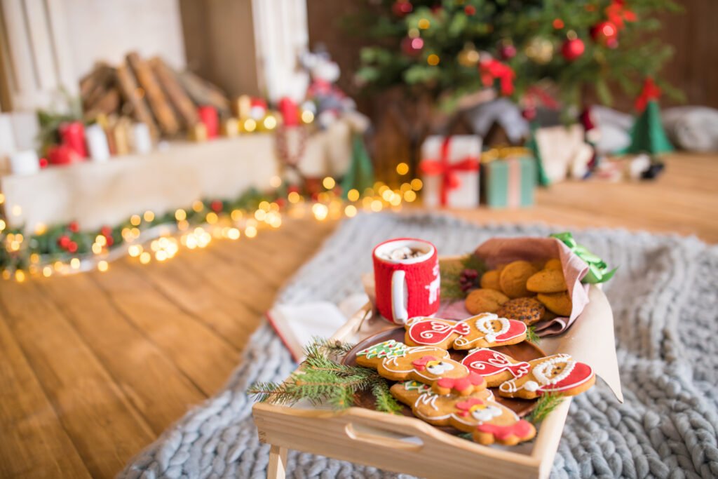 Wooden tray with christmas cookies and hot chocolate in cup on grey carpet